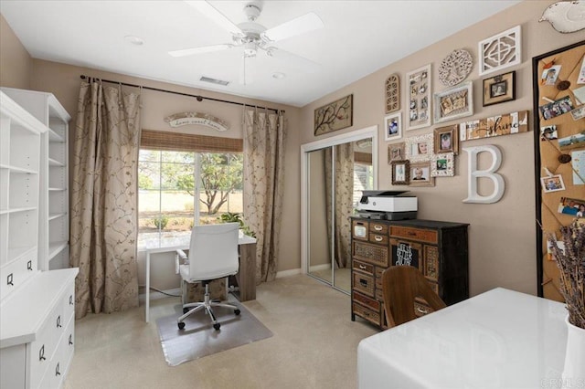 carpeted office space featuring ceiling fan