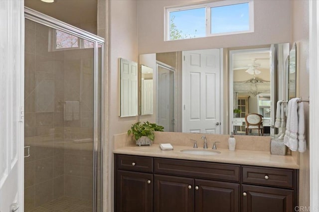 bathroom featuring a shower with door and vanity