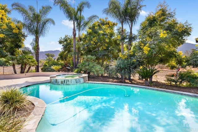 view of pool with an in ground hot tub and a mountain view