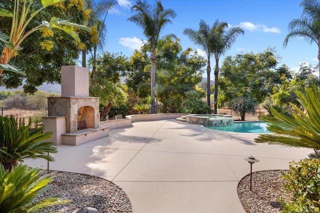 view of pool featuring an in ground hot tub, a patio area, and a tiled fireplace