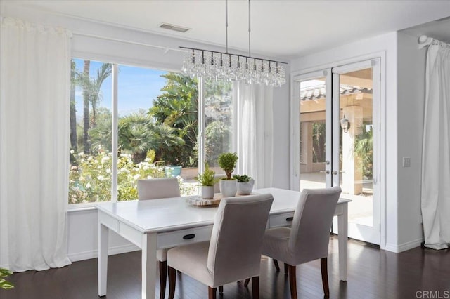 dining room featuring dark wood-type flooring, french doors, and a notable chandelier