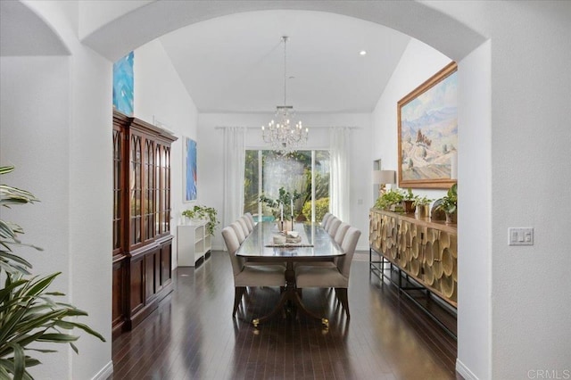 dining space featuring an inviting chandelier, dark wood-type flooring, and vaulted ceiling