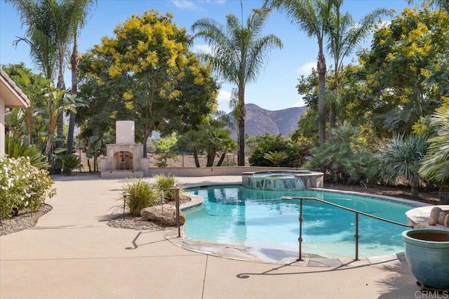 view of swimming pool featuring an in ground hot tub, a patio area, and a mountain view