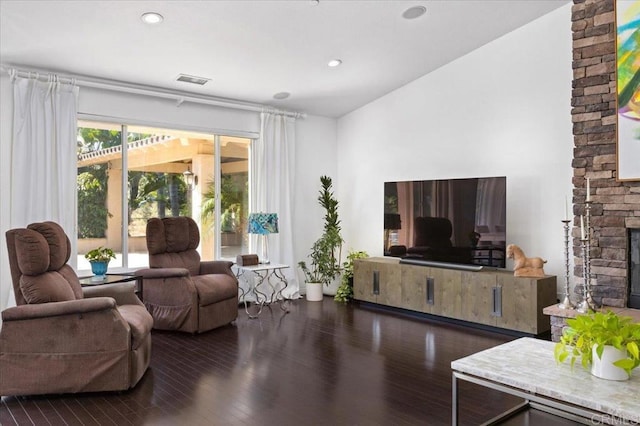 living room featuring a fireplace, a wealth of natural light, and dark hardwood / wood-style flooring