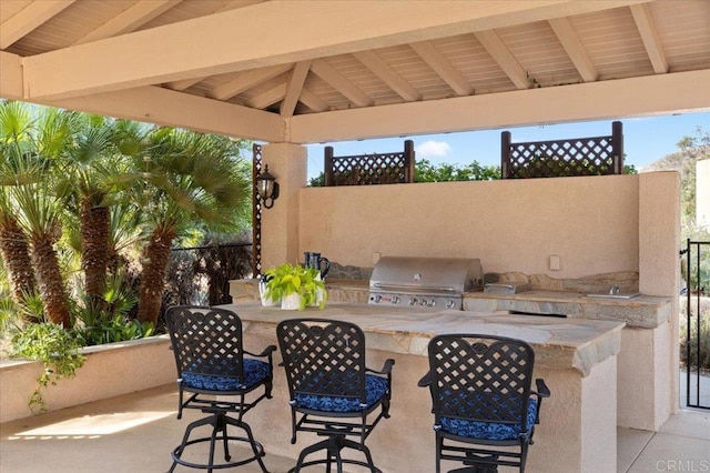 view of patio featuring a gazebo, area for grilling, and a wet bar