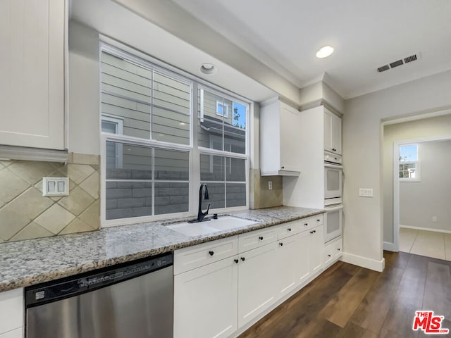 kitchen featuring white cabinets, light stone counters, dark wood-type flooring, sink, and dishwasher