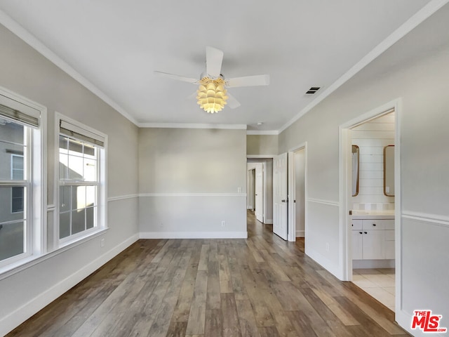 spare room featuring light wood-type flooring, ceiling fan, and crown molding