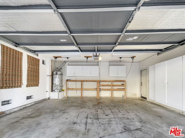 garage featuring strapped water heater and a garage door opener