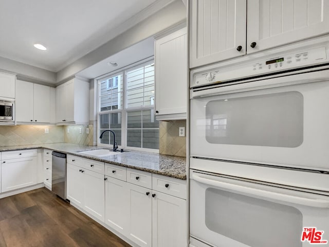 kitchen featuring light stone countertops, white cabinets, stainless steel appliances, and dark hardwood / wood-style floors