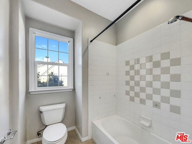 bathroom featuring toilet and tiled shower / bath