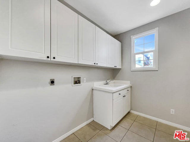 laundry area featuring cabinets, hookup for a washing machine, electric dryer hookup, sink, and light tile patterned floors