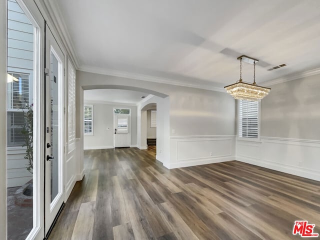 interior space featuring dark hardwood / wood-style floors, crown molding, and an inviting chandelier