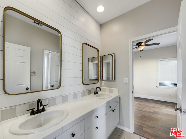 bathroom with ceiling fan, vanity, wood walls, and hardwood / wood-style flooring