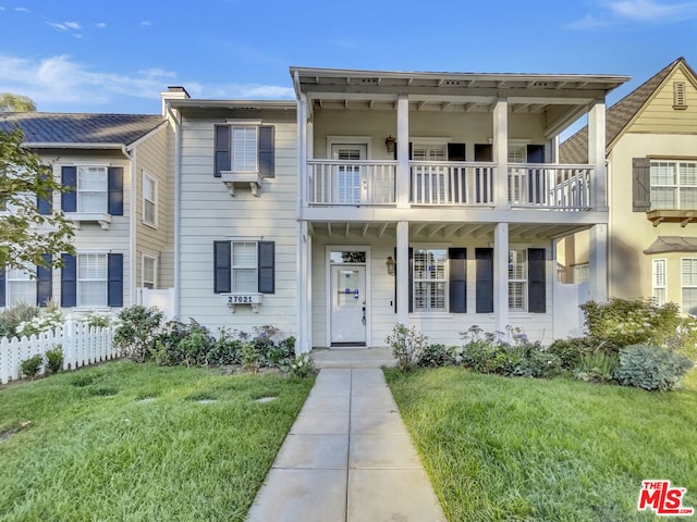 view of front of home featuring a balcony and a front yard