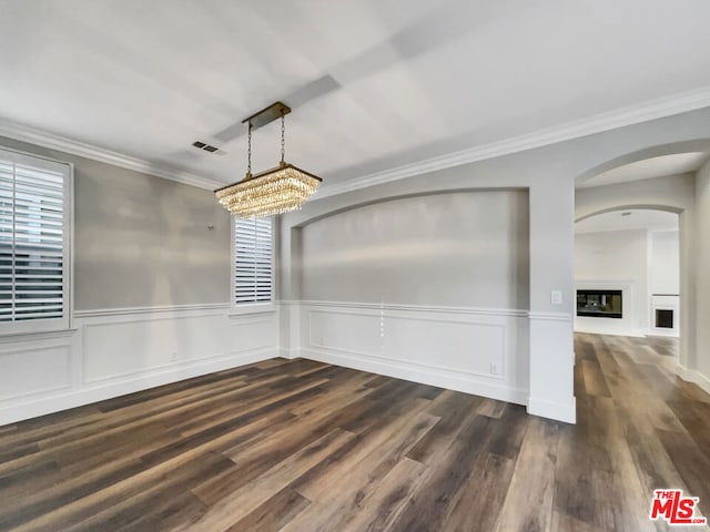 unfurnished dining area featuring a healthy amount of sunlight, ornamental molding, and dark wood-type flooring