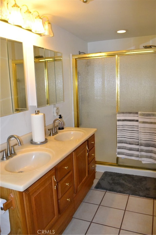 bathroom featuring vanity, a shower with shower door, and tile patterned floors