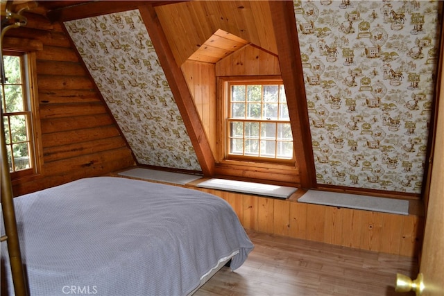 unfurnished bedroom featuring light wood-type flooring, lofted ceiling, and log walls