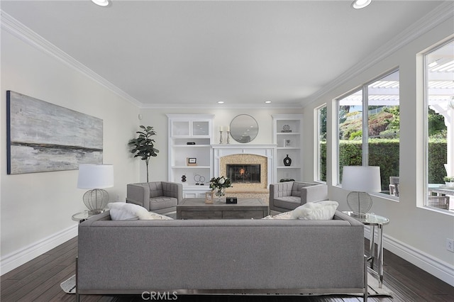 living room featuring ornamental molding, dark hardwood / wood-style floors, a fireplace, and built in shelves