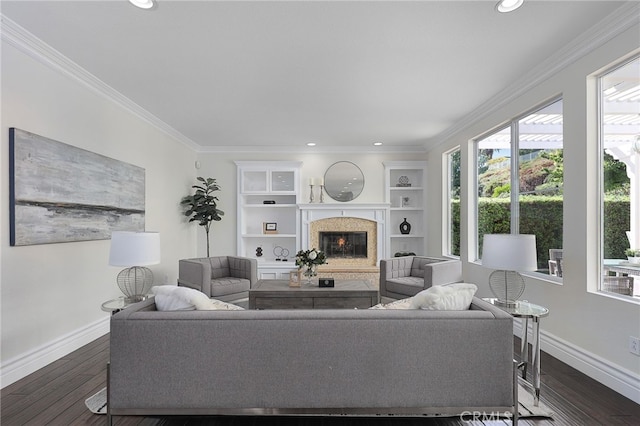 living room featuring crown molding, a high end fireplace, dark hardwood / wood-style floors, and built in features