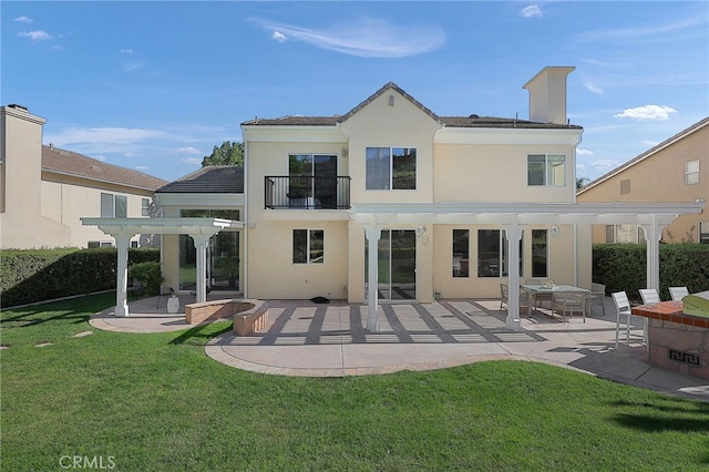 back of property with a balcony, a yard, a patio area, and a pergola