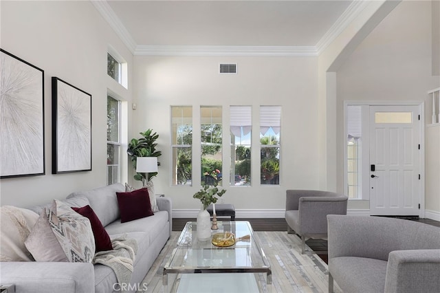 living room featuring crown molding, a healthy amount of sunlight, and hardwood / wood-style floors