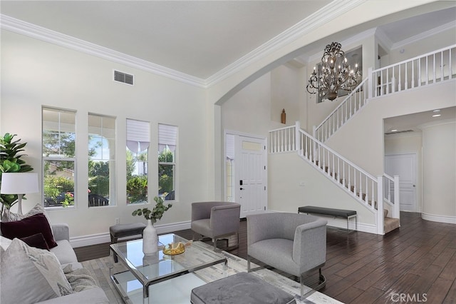 living room with a high ceiling, crown molding, dark hardwood / wood-style floors, and a notable chandelier