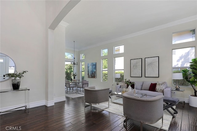 living room featuring ornamental molding, a healthy amount of sunlight, and dark hardwood / wood-style flooring