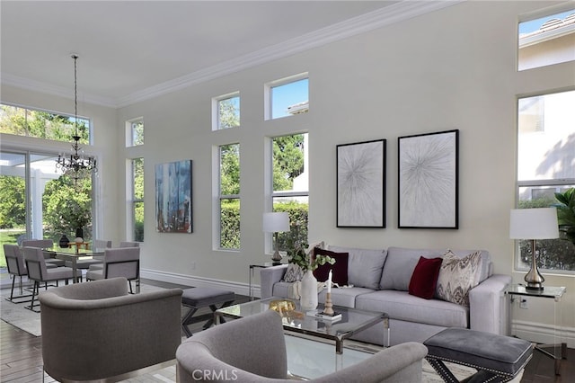 living room with hardwood / wood-style flooring, a wealth of natural light, ornamental molding, and a chandelier