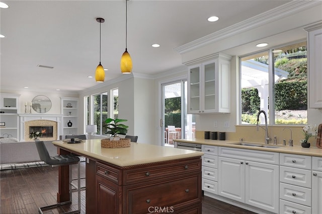 kitchen featuring a healthy amount of sunlight, sink, white cabinets, and a kitchen bar