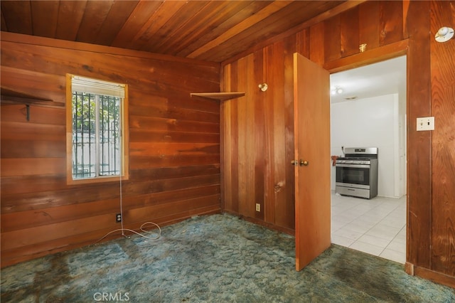 spare room featuring wood ceiling, wood walls, and light tile patterned floors