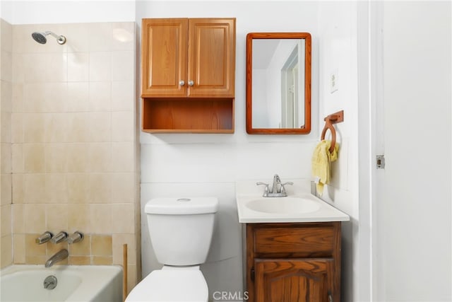 full bathroom featuring tiled shower / bath, vanity, and toilet