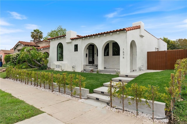 mediterranean / spanish-style home with a front lawn