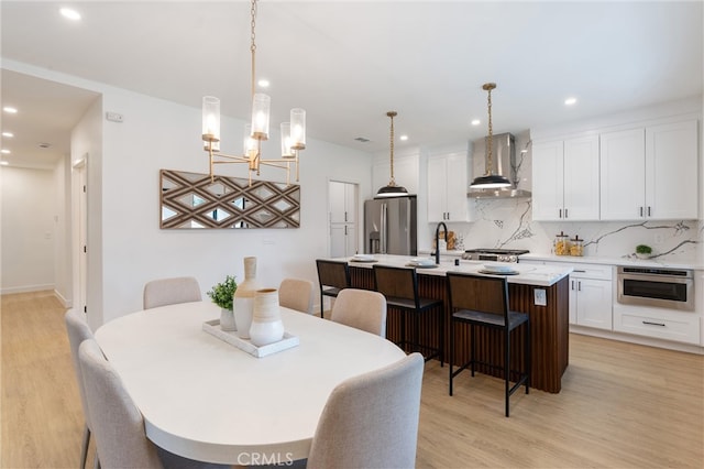 dining area featuring light wood-type flooring and a notable chandelier