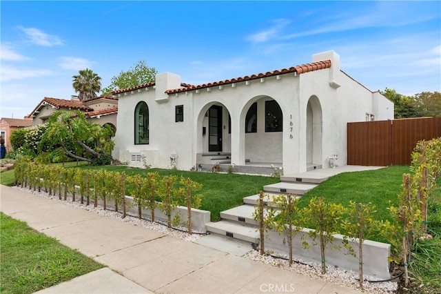 mediterranean / spanish home featuring a front yard