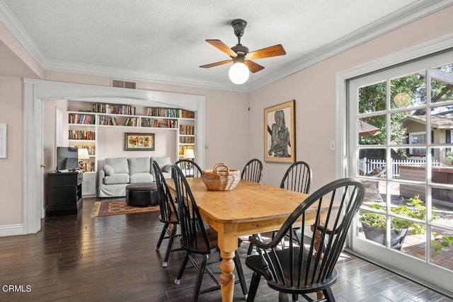 dining area featuring a textured ceiling, ceiling fan, crown molding, and dark wood-type flooring