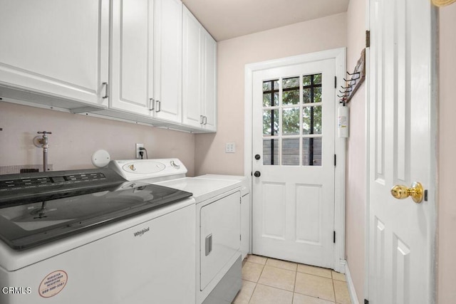 laundry area featuring cabinets, washing machine and dryer, and light tile patterned floors