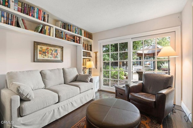 living room featuring a textured ceiling, a wealth of natural light, and dark hardwood / wood-style floors