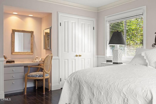 bedroom featuring built in desk, a closet, and crown molding