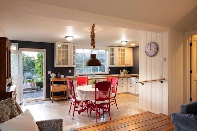 dining space with wooden walls, a healthy amount of sunlight, and sink