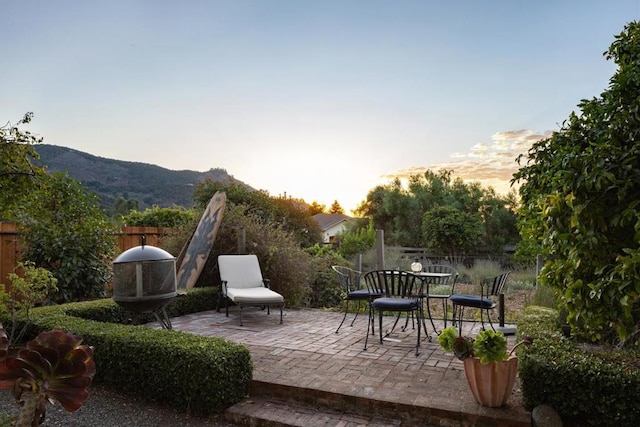 patio terrace at dusk featuring a mountain view