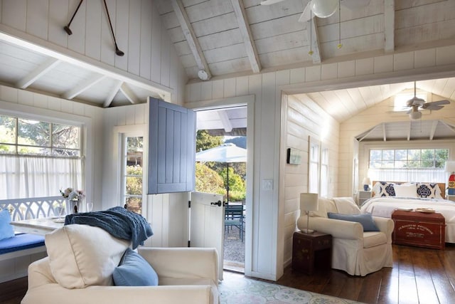 interior space with wood walls, wooden ceiling, lofted ceiling with beams, dark hardwood / wood-style floors, and ceiling fan