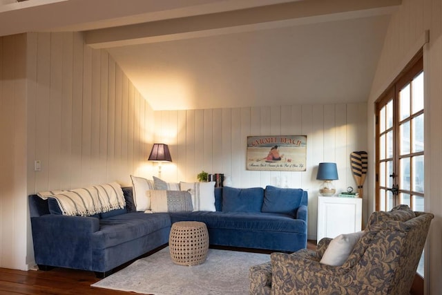 living room with vaulted ceiling with beams, wood walls, and dark hardwood / wood-style floors