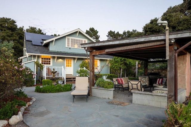 back of house with solar panels, an outdoor hangout area, and a patio