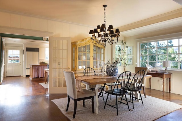 dining area with a notable chandelier, dark hardwood / wood-style flooring, plenty of natural light, and ornamental molding