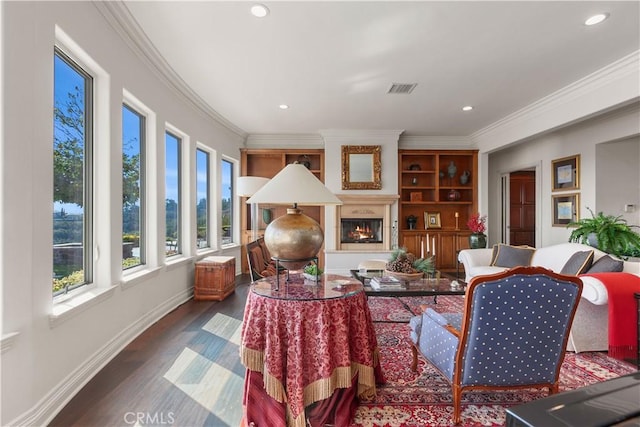 living room with a large fireplace, crown molding, and dark hardwood / wood-style flooring