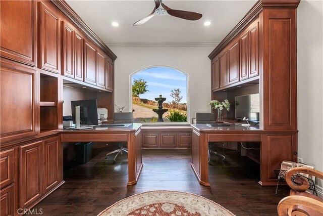 office space with ceiling fan, dark wood-type flooring, ornamental molding, and built in desk