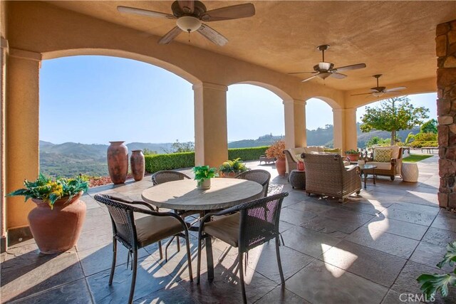 view of patio / terrace with a mountain view and ceiling fan