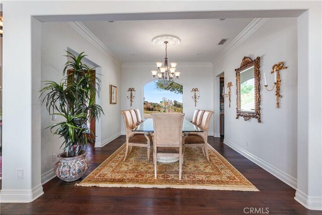 dining room featuring dark hardwood / wood-style flooring, crown molding, and an inviting chandelier