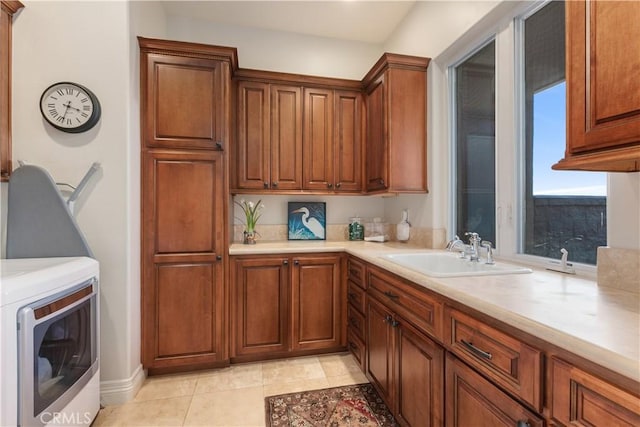 26088 Calle Catrina, Temecula, CA 92590 - kitchen with a sink, washer / dryer, light countertops, brown cabinets, and light tile patterned flooring