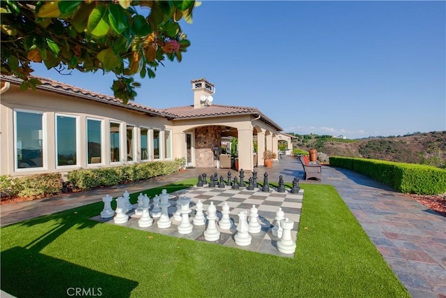 back of house featuring a lawn and a patio area